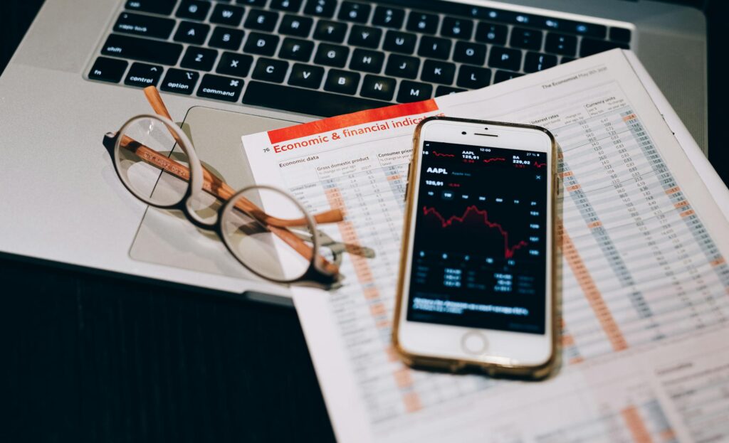 A detailed look at financial tools including a smartphone and laptop for stock analysis.
