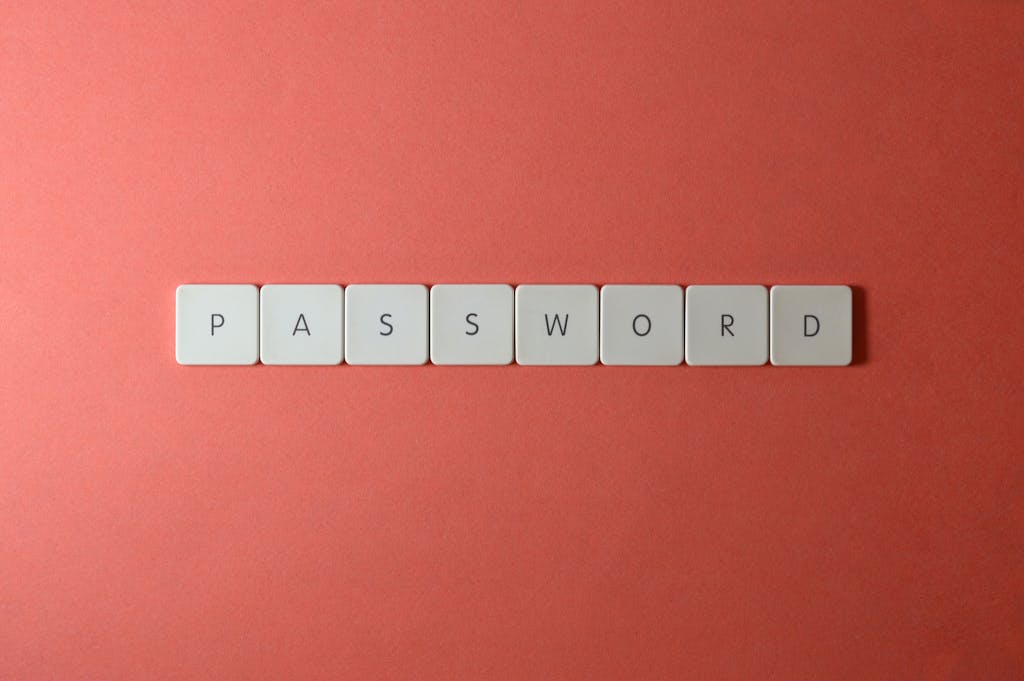 Focus on password security with white keyboard tiles spelling 'PASSWORD' on a coral background.
